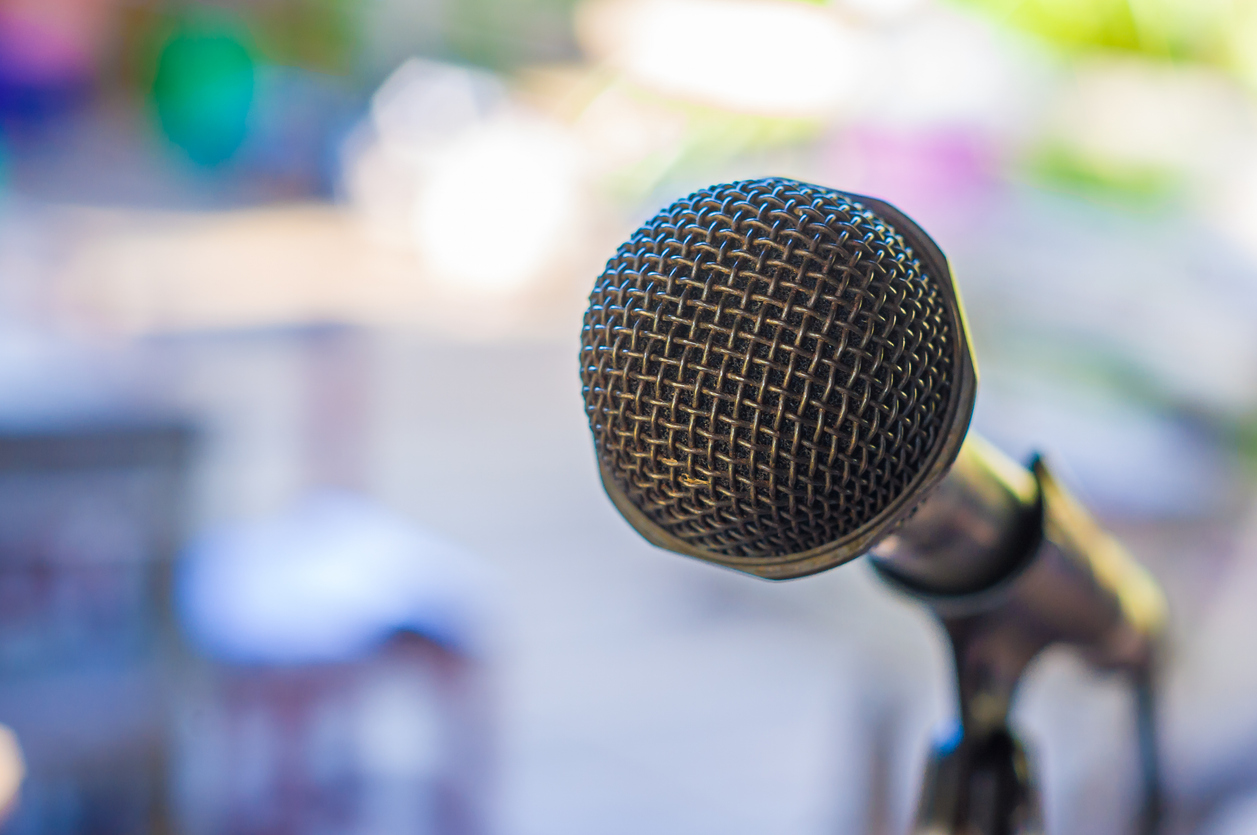 Close-up photo of microphone with blurred background of lights