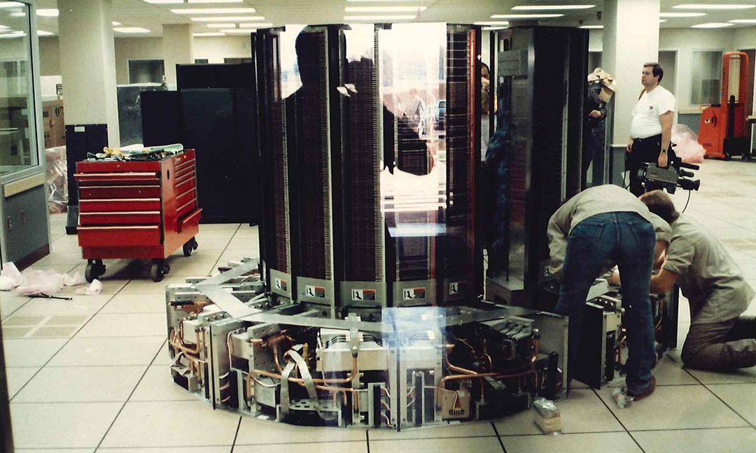 Two men working on installing the Cray XMP on datacenter floor exposing internal components