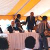 Governor Guy Hunt speaking and presenting plaque at podium outdoors under yellow and white tent pavillion at dedication of Alabama Supercomputer Center